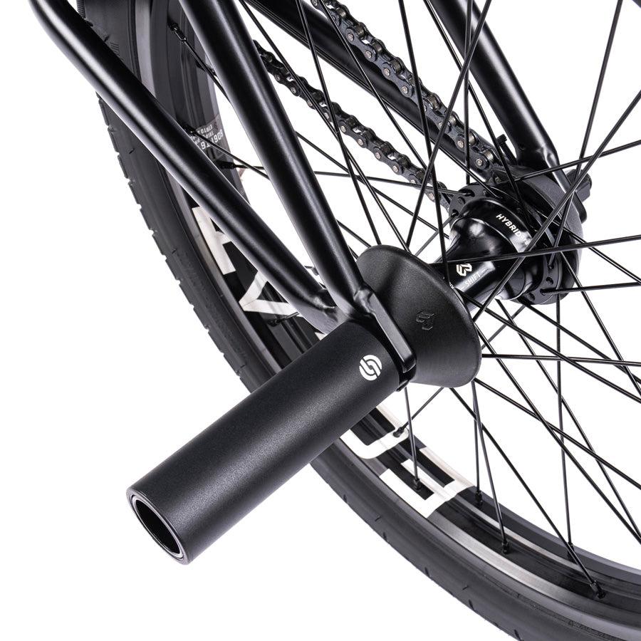 Close-up of the Wethepeople Trust 20 Inch Freecoaster/Hybrid Bike wheel featuring a black stunt peg attached to the axle. The spokes and chain are also visible, perfectly showcasing its battleship geometry design.