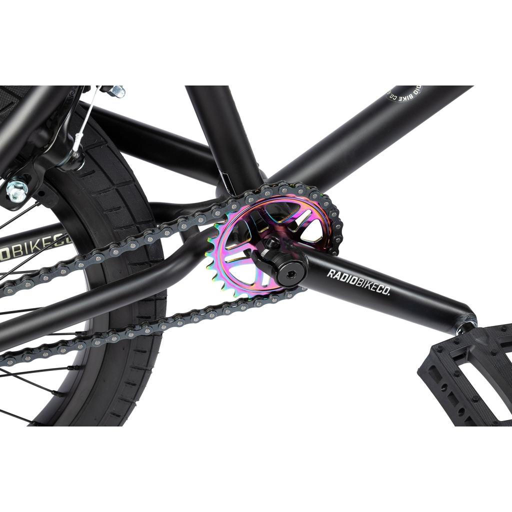 Close-up of the Radio Evol XL 20 Inch Bike crankset featuring a black "RADIOBIKECO." crank arm and a multicolored chainring with the chain—perfect for entry-level BMX riders with its sealed integrated headset.