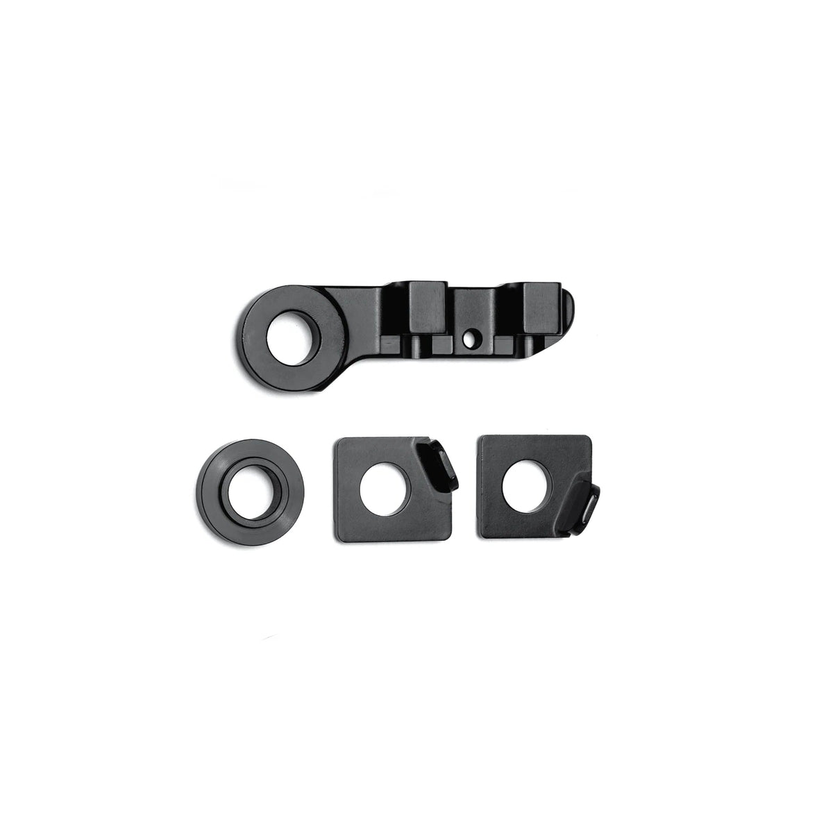 The DK Zenith Disc Frame Flat Mount Brake/Axle Hardware Kit includes four black metal components—one elongated bracket with holes and three square or round washers—arranged on a white background, perfect for thru-axle setups.