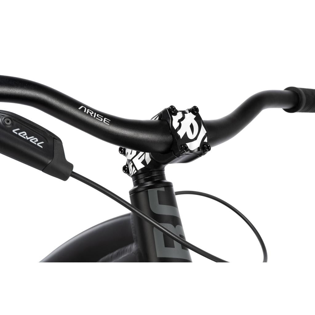 Close-up of the Radio 26 Inch Griffin Pro Bike’s black handlebars, stem, and brake lever, with "ARISE" and "LEVEL" branding visible on its sturdy alloy frame.