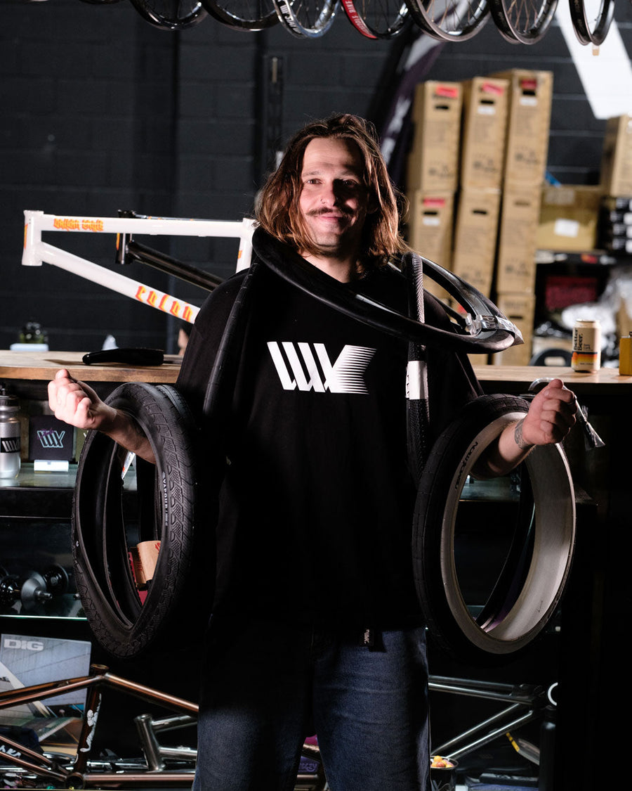 LUXBMX crew member holding BMX tyres in the shop