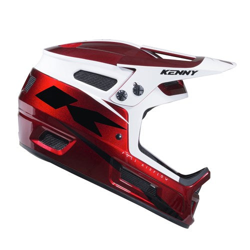 The Kenny Racing Elite Helmet Candy Red + Glitter & Varnish is a glossy red and white full-face motocross helmet featuring black accents, ventilation openings, and a visor. The brand name “Kenny” is printed on the side above the visor.