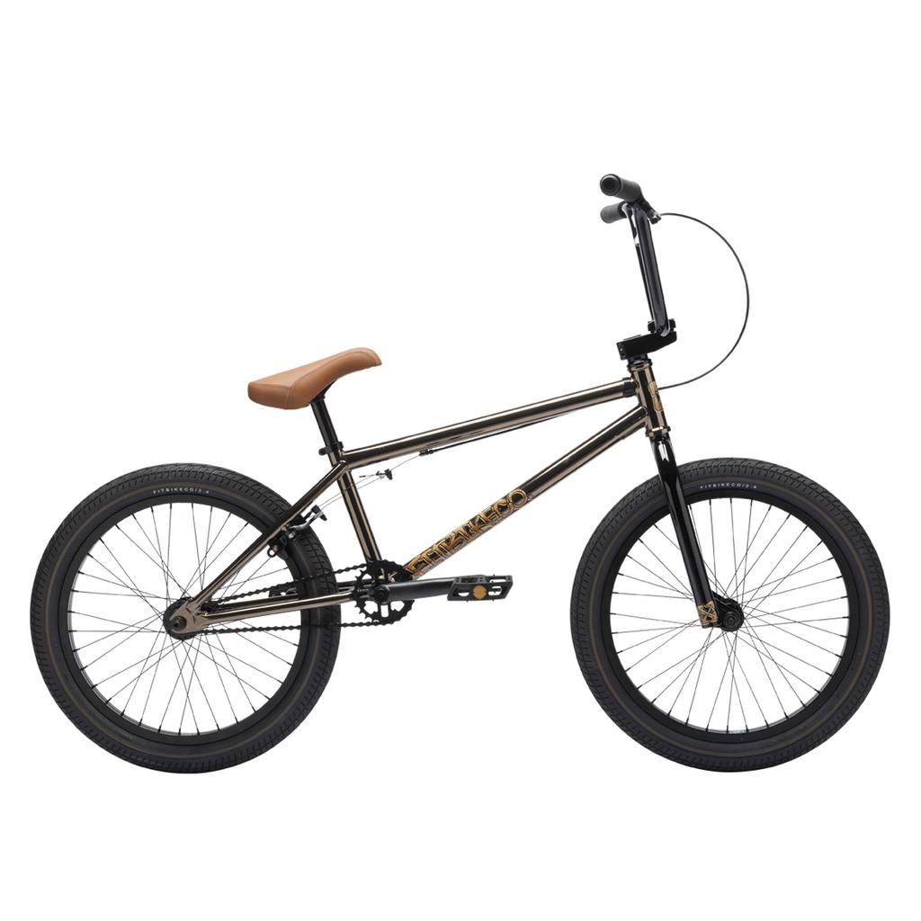 The Fit Bike Co Series One Bike features a Cro-Mo frame, brown seat, gold finish, black handlebars, and black tires, displayed in side profile against a white background.