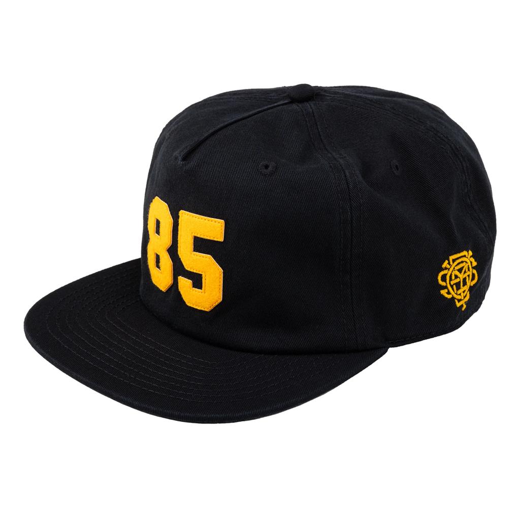 Gear up for Back to School 2025 with the Odyssey 85 Cap—a stylish black 5-panel hat featuring a bold yellow "85" on the front and a small yellow embroidered emblem on the side.