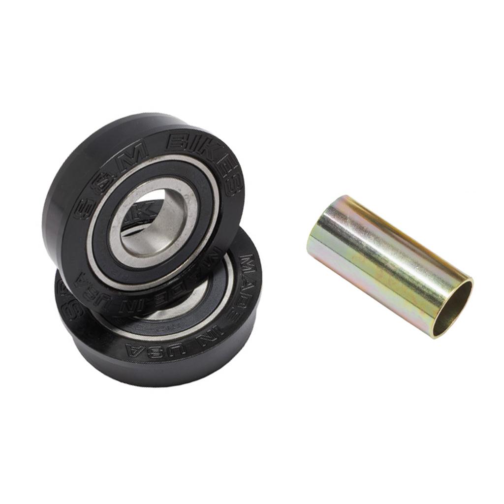 Two black sealed ball bearings labeled "ESM BIKES" are stacked next to a metallic spacer on a white background—key components of the S&M USA Bottom Bracket Set for American BB setups or BMX bottom brackets.