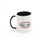 The Redline Northridge CA Coffee Mug is a 12oz white ceramic mug with a black handle and rim, featuring the bold red and black "Red Line Racing Frames" logo. Ideal for Redline mug collectors or racing enthusiasts.