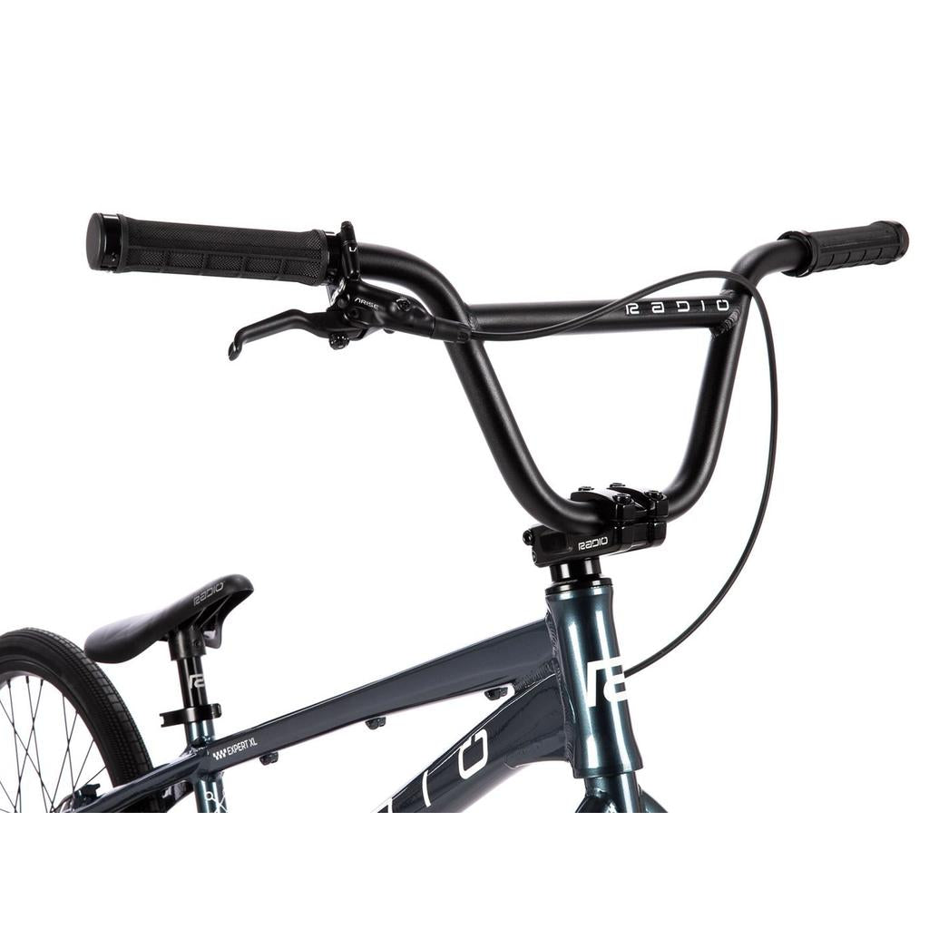 Close-up of the Radio Xenon Expert XL Disc 20 Inch Bike’s black handlebars, brake lever, a portion of the seat, and its lightweight alloy frame, viewed from the front left side.
