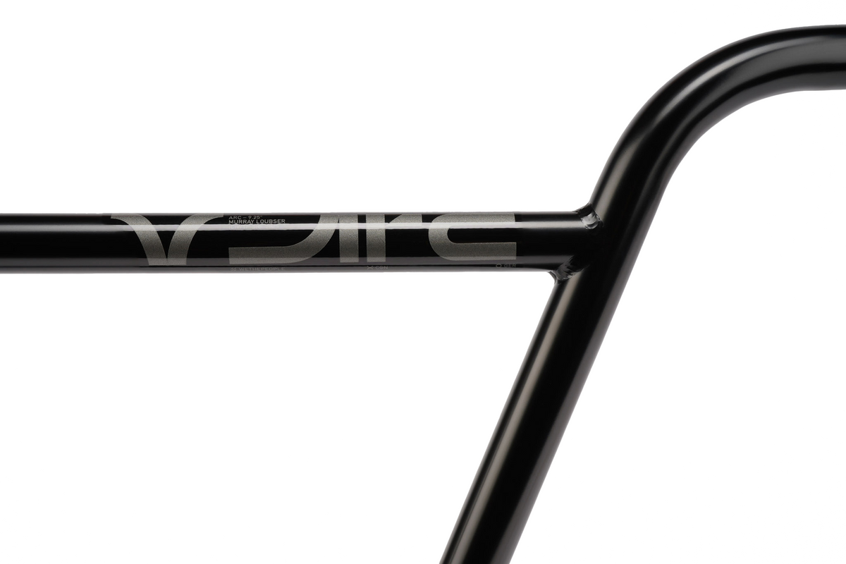 Close-up of a black Wethepeople ARC (Murray Loubser) Bars / OS 25.4mm Clamp street BMX handlebar, featuring a silver “Eclat” logo on the crossbar. Crafted from durable 4130 chromoly and photographed against a white background, this Murray Loubser signature model exemplifies both strength and style for demanding riders.