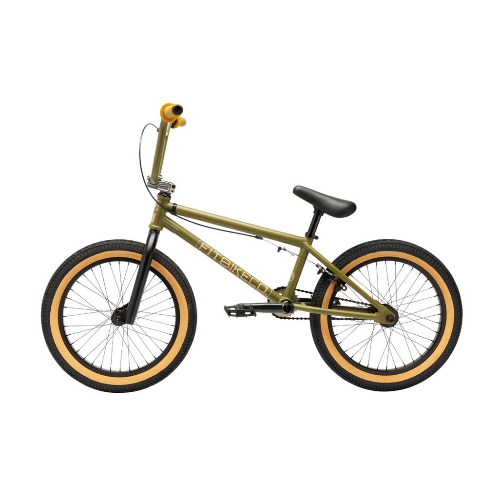 A side view of the Fit Bike Co Misfit 18 Inch Bike, a green youth BMX with black handlebars, seat, and wheels, tan sidewall tires, and yellow handlebar grips.
