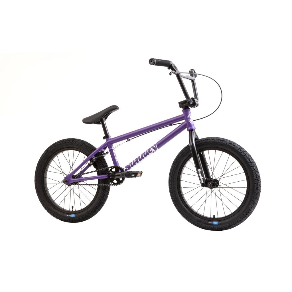 The Sunday Primer 18 Inch Bike (2025) features a purple pro-style BMX frame, black handlebars, seat, and tires, shown side view against a white background.