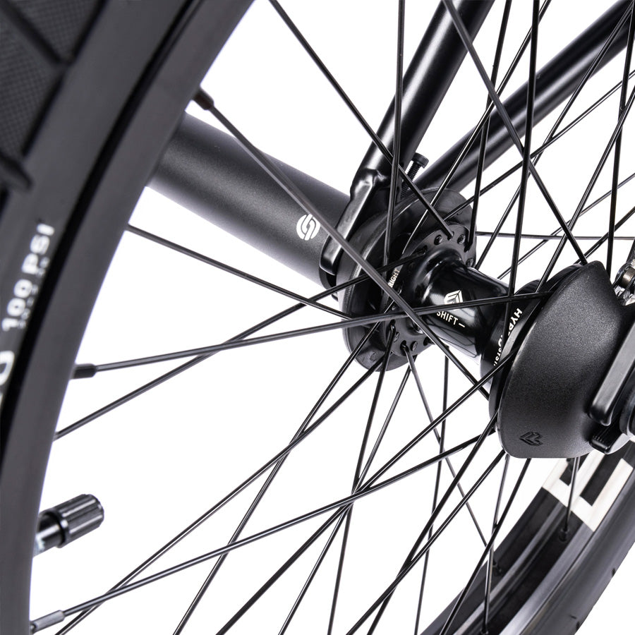 A close up of a black Wethepeople Trust 20 Inch Freecoaster Bike wheel with spokes.