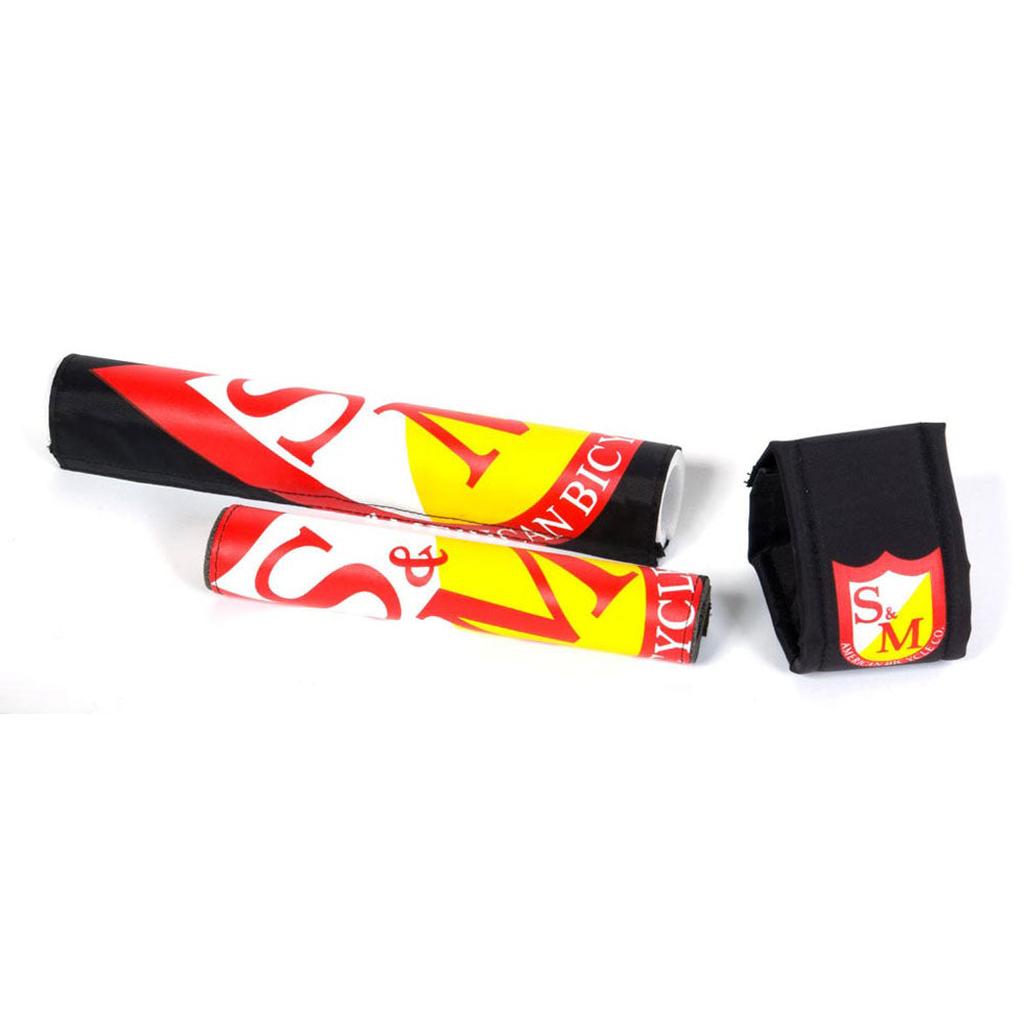 The S&M Race Pad Set includes three accessories: two handlebar crossbar pads and one top tube pad, all in bold red, yellow, and white with prominent S&M logos.
