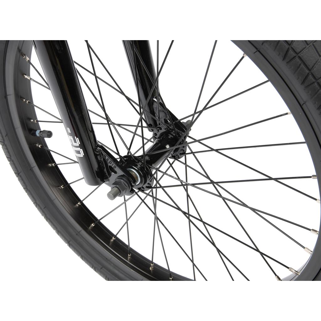 Close-up of the Radio Revo Pro FS 20 Inch Bike’s black BMX wheel, showing tire, spokes, axle, and fork against a white background; features classic 20-inch top tube geometry.