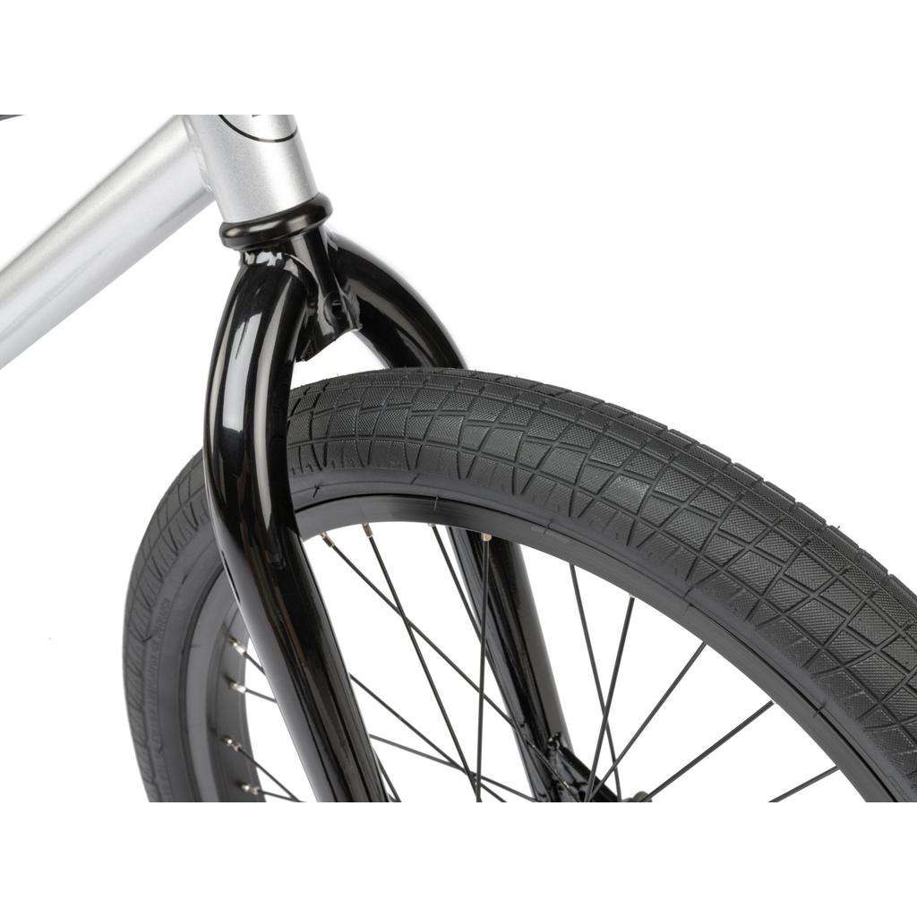 A close-up of the Radio Revo Pro 20 Inch Bike’s front wheel, highlighting its black tire, spokes, and part of the black fork against a white background.