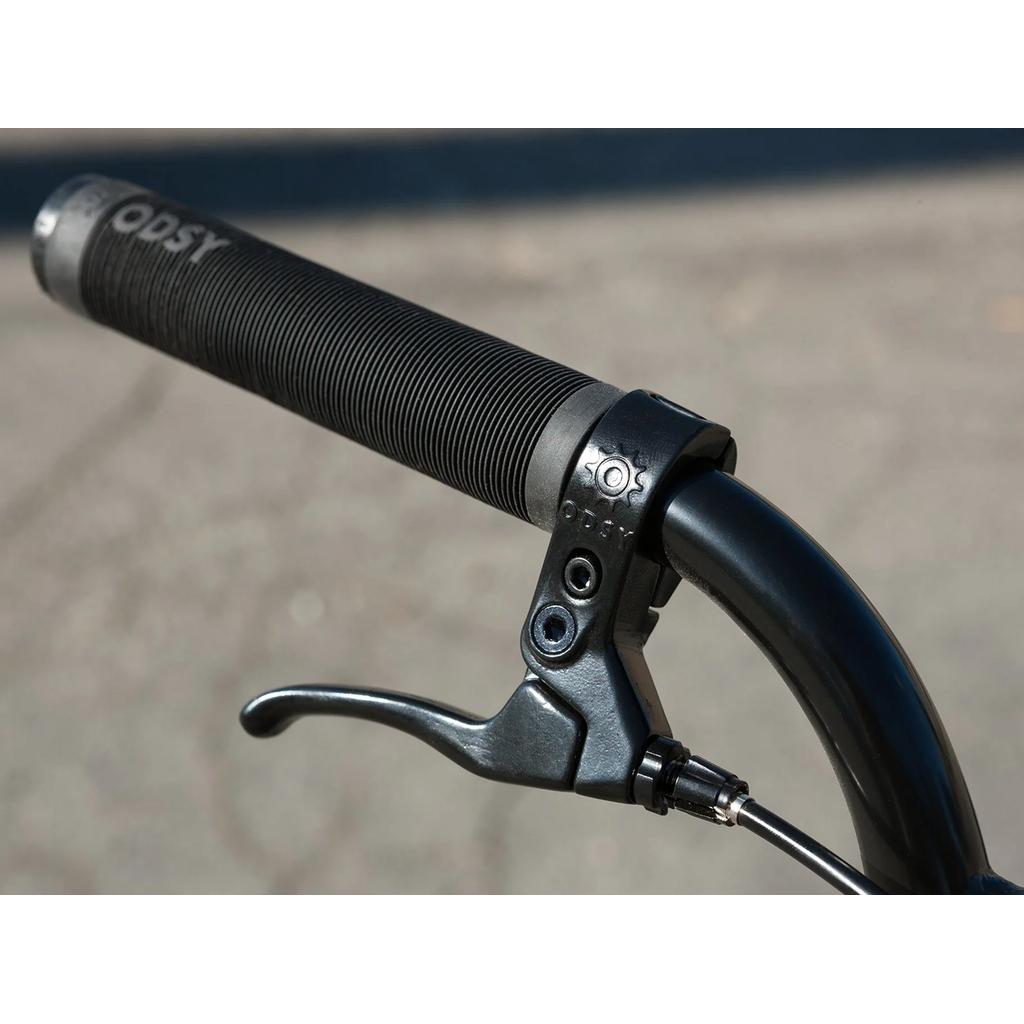 Close-up of a black handlebar with textured grip and brake lever, photographed outdoors—ideal for those upgrading their Sunday Scout 20 Inch Bike or seeking quality BMX parts.