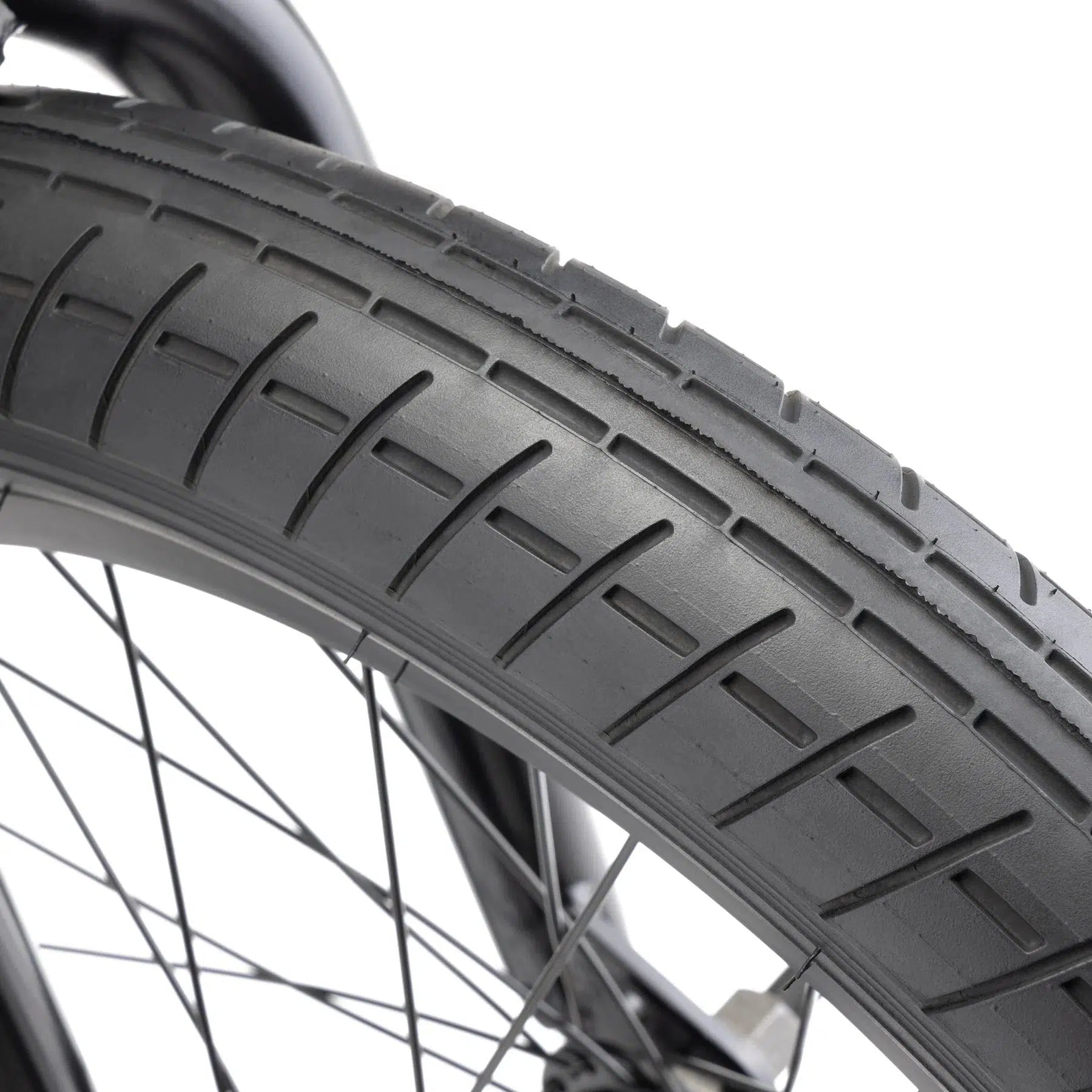 Close-up image of the Kink Kicker 18 Inch Bike’s tire, highlighting the detailed tread pattern and part of the wheel's spokes, exemplifying its superior ride quality ideal for younger riders.
