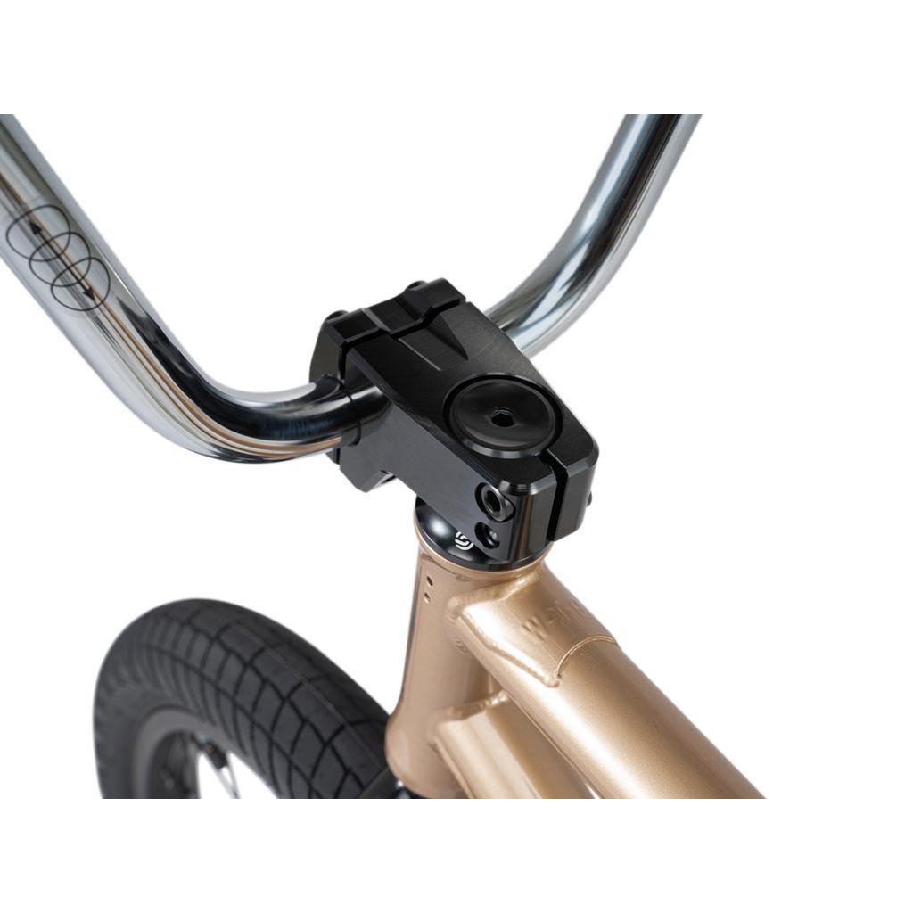Close-up of the Wethepeople Crysis 20 Inch BMX Bike’s handlebar stem and front tire, highlighting its metallic gold frame and SaltPlus black stem hardware against a white background.