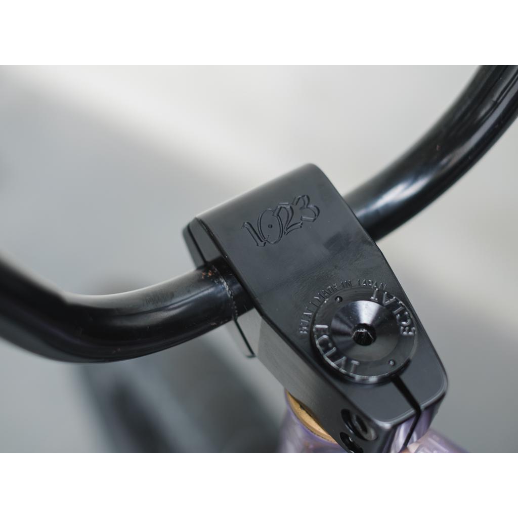 Close-up of black handlebars on a bike with the limited-edition Eclat 1023 Stem, embossed with "1623" and capturing mid-school styling.