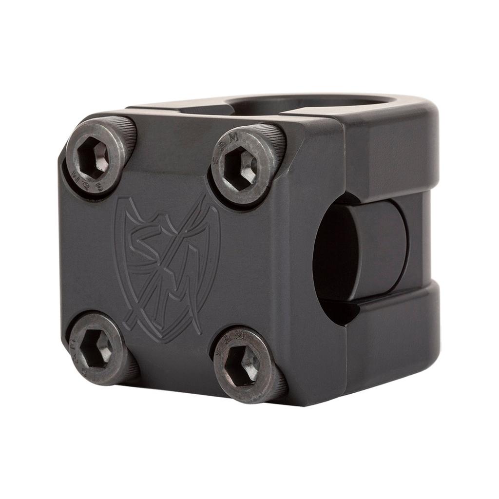 The S&M Redneck FLT Flatland Stem boasts a black metal build, four hex bolts, and an engraved shield logo up front, echoing the durable style of classic BMX flatland stems.