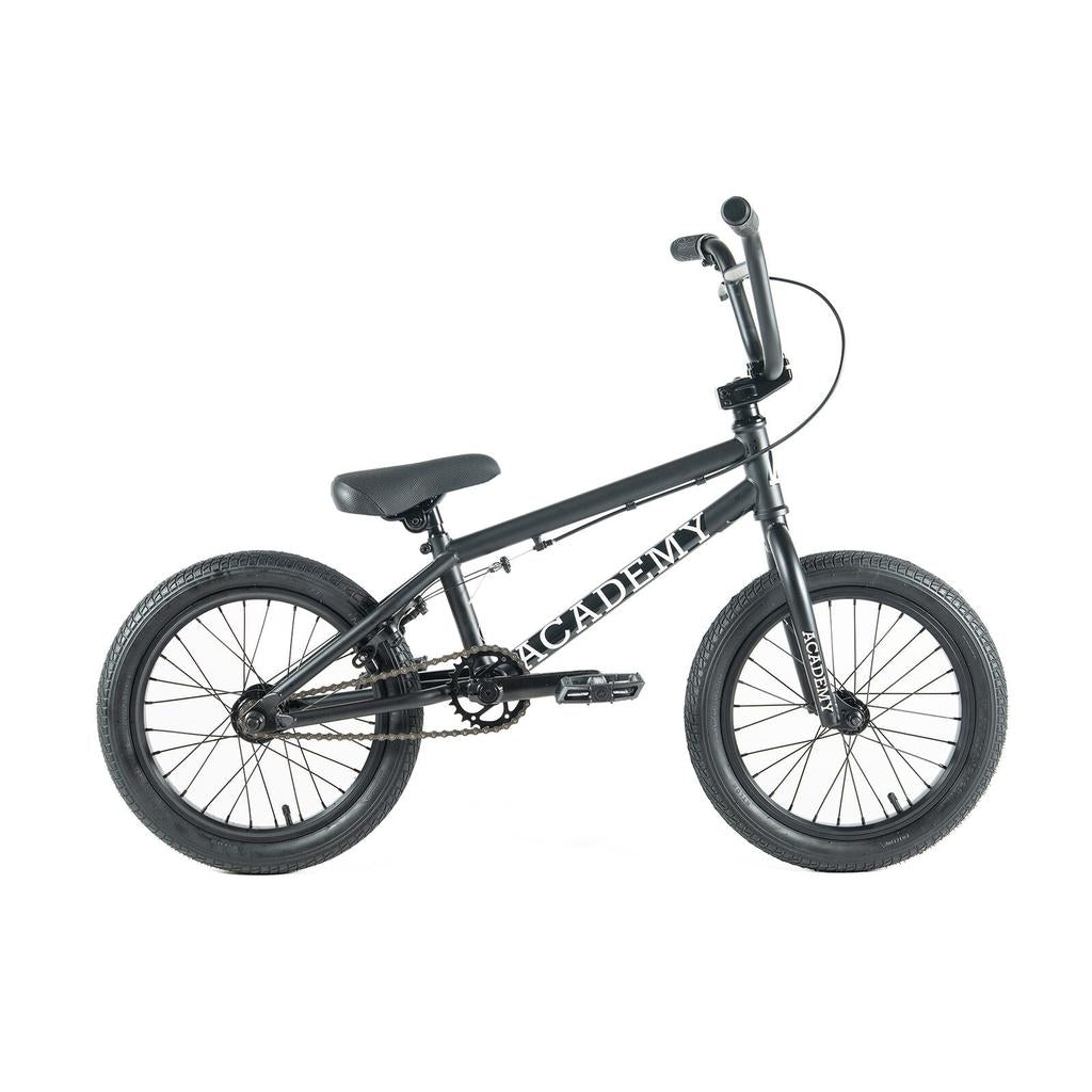 The Academy Inspire 16 Inch Bike is a black BMX-style bicycle featuring thick tires, double wall rims, a padded seat, and "Academy" on the frame, shown against a white background.