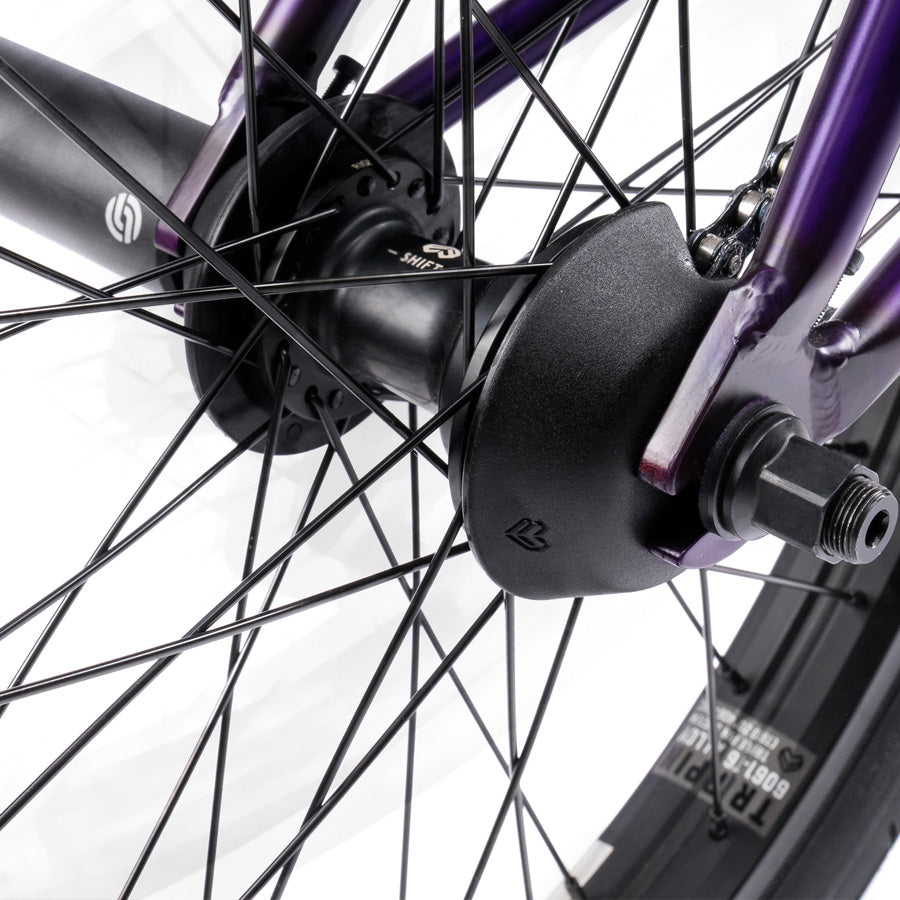 A close up of a purple BMX wheel with black spokes featuring the Wethepeople Trust 20 Inch Cassette Bike.