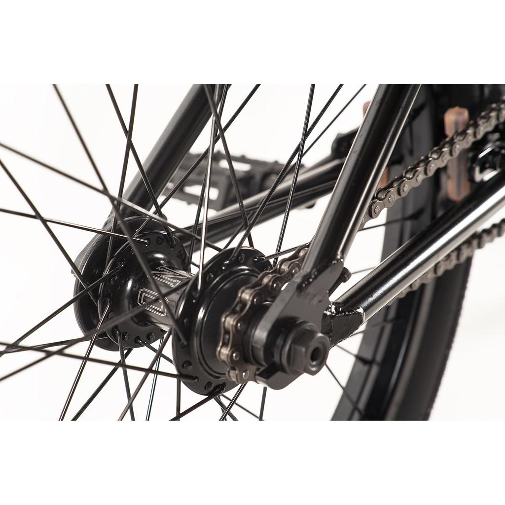 Close-up of the Colony Prody Pro 20 Inch Bike's rear wheel, highlighting the hub, spokes, chain, and black metal frame against a white background.