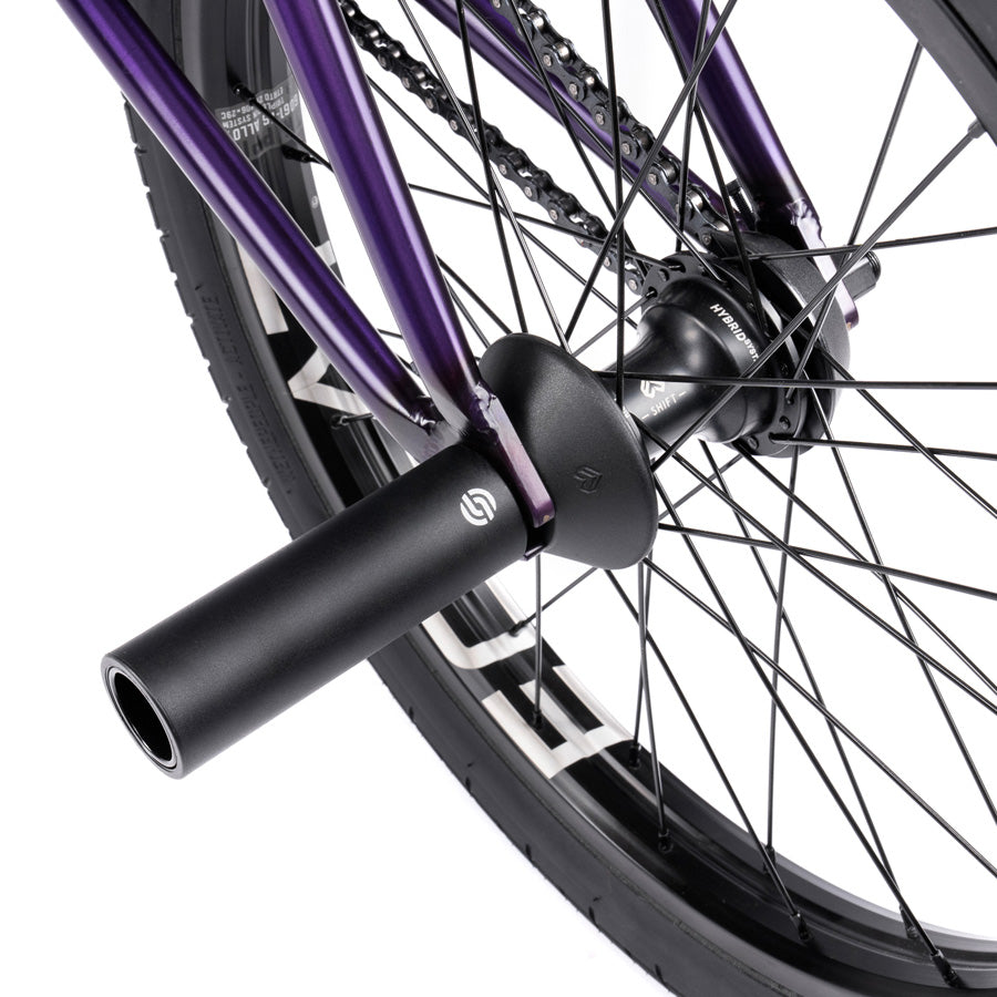 A close up of a purple bike wheel with black spokes featuring the Wethepeople Trust 20 Inch Cassette Bike.