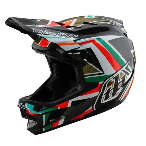 The TLD 25.1 D4 Carbon Helmet (MIPS) in black and gold boasts stylish geometric designs, showcasing "Troy Lee Designs." Perfect for downhill BMX riders, it combines sleek aesthetics with MIPS protection to enhance safety on each ride.