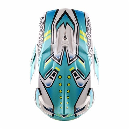 Top view of the TLD 26.1 D4 AS Composite Helmet in Crest Real Teal, featuring blue, teal, and white geometric patterns, "Troy Lee Designs" text on both sides, and a Mips system for enhanced safety.