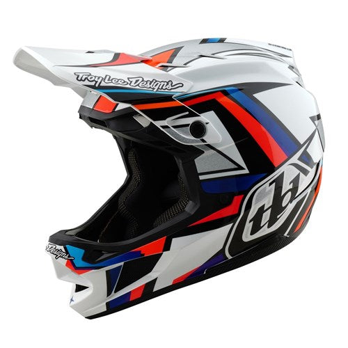 The TLD 25.1 D4 Composite Helmet (MIPS) in white/silver is a full-face motocross helmet featuring blue, red, and black geometric patterns with a visor for optimal protection.