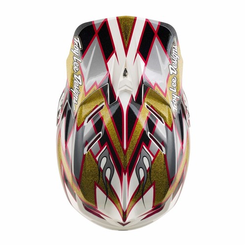 The TLD 26.2 D4 Composite Helmet / MIPS Flush Black is a motocross full-face helmet adorned with red, black, white, and gold angular patterns visible from above. It features “Troy Lee Designs” text on each side and is equipped with integrated Mips protection for added safety.
