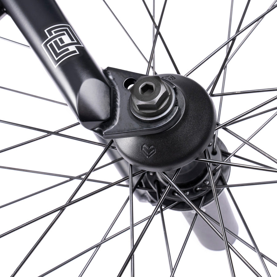 A close up of a black bicycle wheel featuring the Wethepeople Trust 20 Inch Cassette Bike with Hybrid Technology.