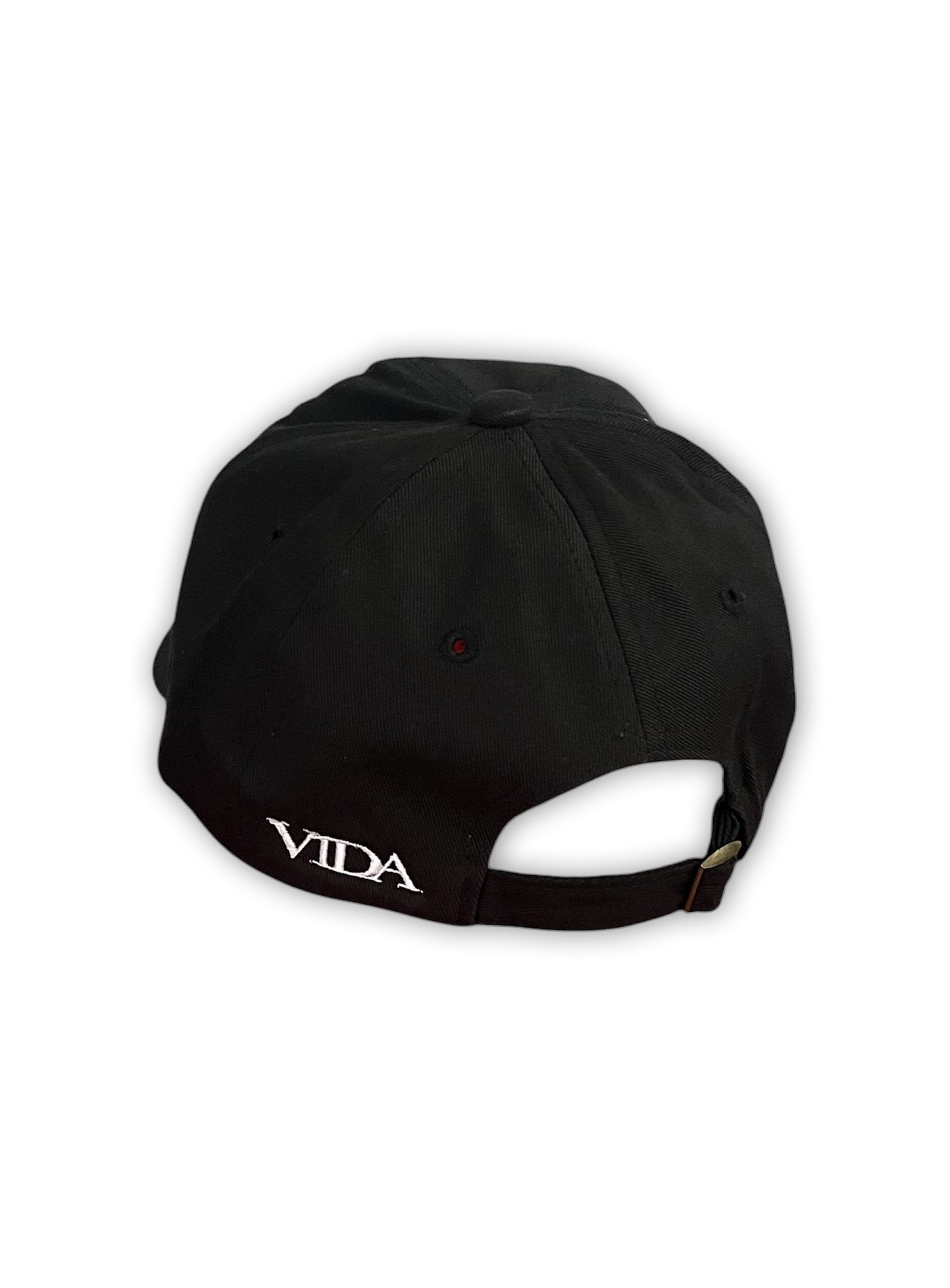 V1da The Dad Cap, shown from the back, features "VIDA" embroidered in white above the adjustable strap. This unstructured black hat offers a classic, low-profile fit.
