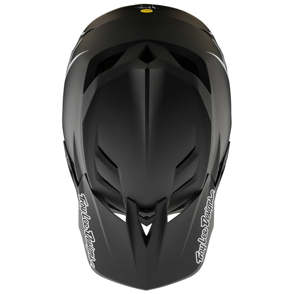 The TLD D4 AS Polyacrylite Helmet W/MIPS Stealth Black features a matte finish and bold visor logos, shown from a top-down view.