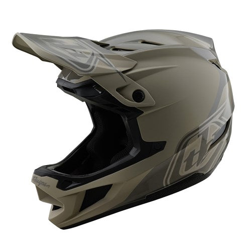 The TLD D4 Polyacrylite Helmet (MIPS) / Shadow Timber is a tan and black full-face motocross helmet with a visor, designed for off-road use. It boasts a durable Polyacrylite shell, vibrant side graphics, and Mips brain protection for superior safety.