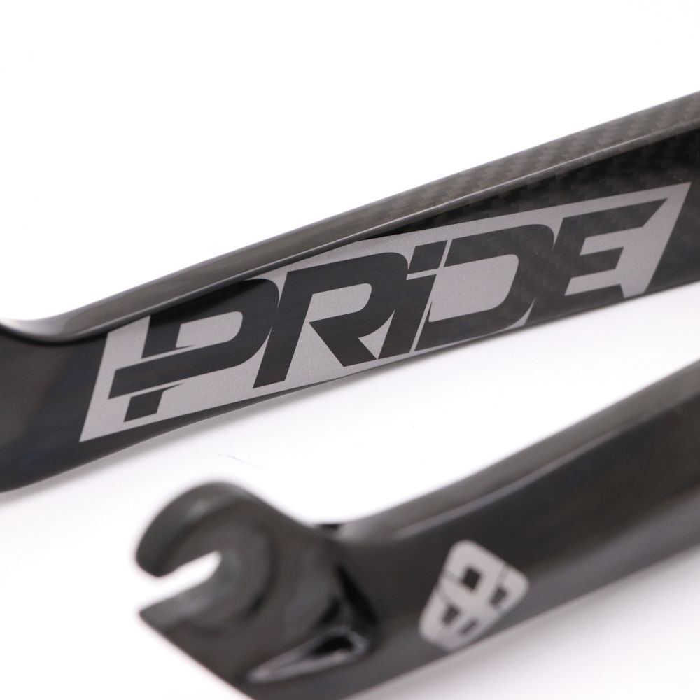Close-up of the Pride Apex 20 Inch 10mm Fork, featuring a black carbon finish, 1-1/8 inch steerer, and "PRIDE" printed in bold gray letters on the side.