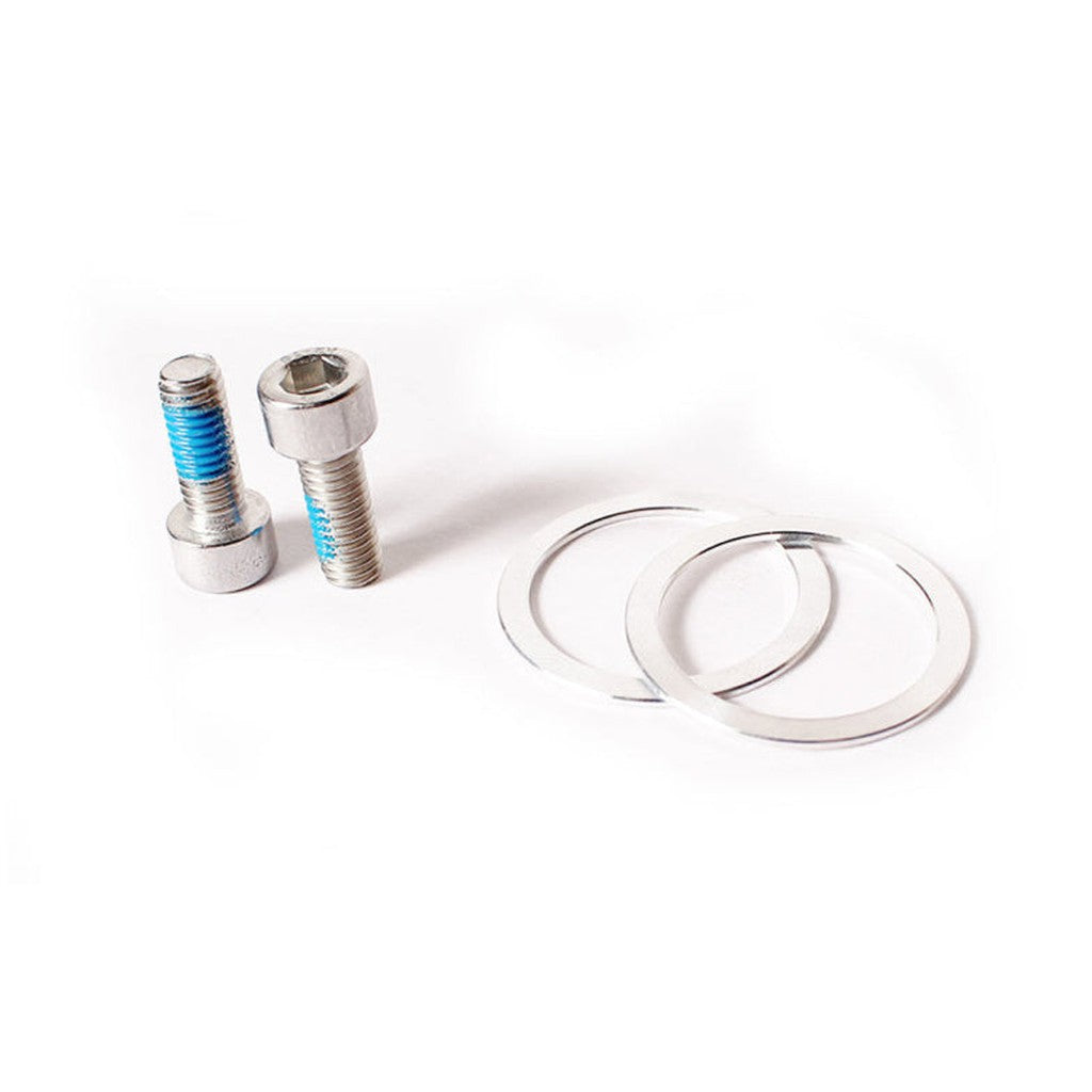 A pair of metal bolts featuring blue threads, identified as components of the Beringer Crank Arm Bolt & Spacer Kit, are positioned beside two flat metal washers on a white background.