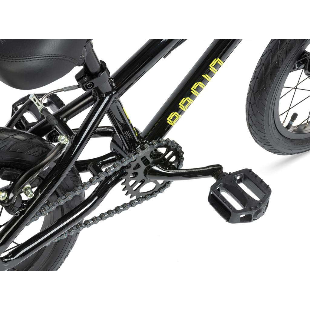 Close-up of the Radio Revo 14 Inch bike’s black pedal, crankset, chain, and rear wheel with yellow frame lettering—ideal detailed features for a child’s first BMX bike.