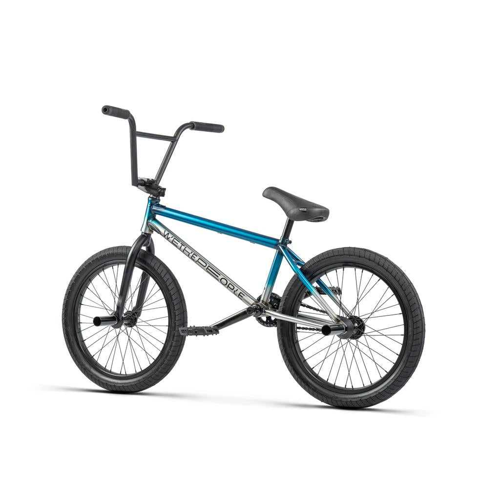 The Wethepeople Reason Shift 20 Inch Bike is a premium BMX with a blue and black full chromoly frame, straight top tube, black handlebars, and thick tires, shown on a white background.