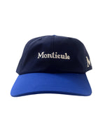 The Monticule Vapor Strap Back Hat is a blue and navy baseball cap featuring "Monticule" embroidered in white on the front. Inspired by classic Vapor Strapback hats, it offers breathable comfort and stylish design.