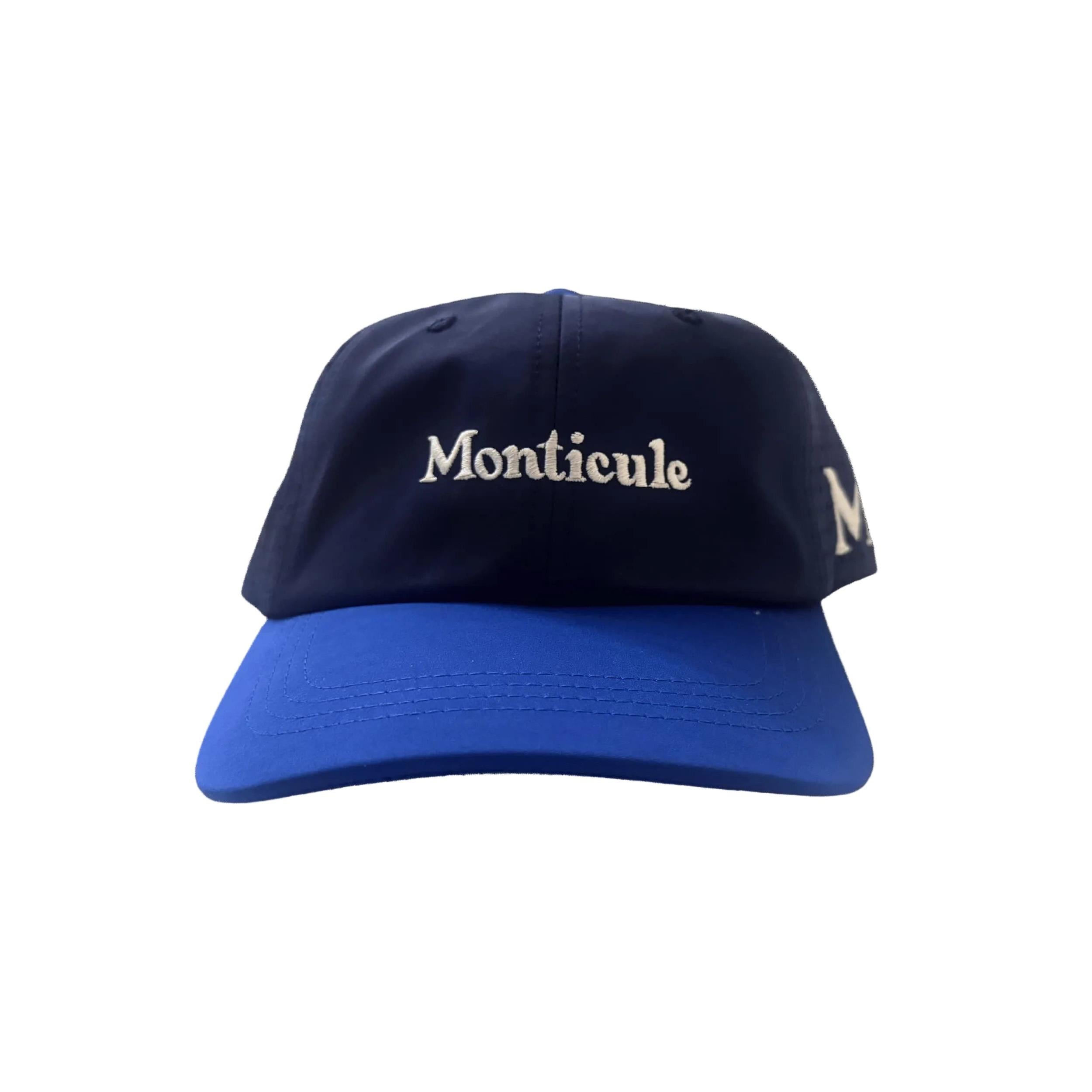 The Monticule Vapor Strap Back Hat is a blue and navy baseball cap featuring "Monticule" embroidered in white on the front. Inspired by classic Vapor Strapback hats, it offers breathable comfort and stylish design.