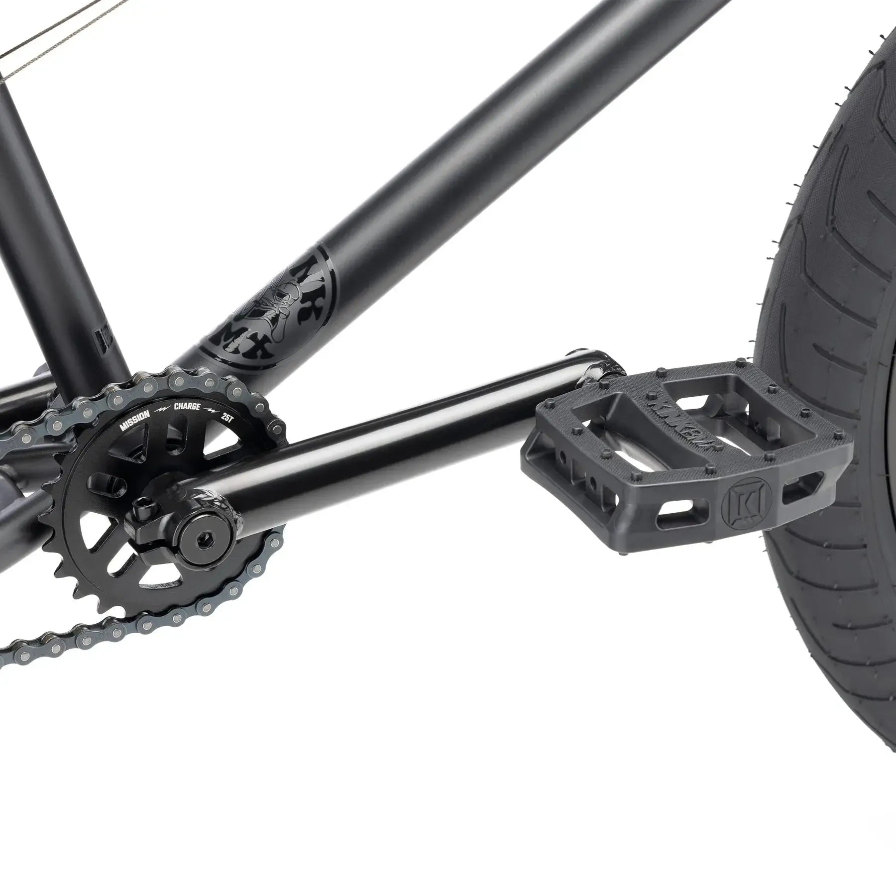 Close-up of the Kink Whip 20 Inch Bike (2026) showing its 4130 chromoly BMX crankset, chainring, pedal, and rear tire on a matte black frame.