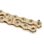 Close-up of a gold-colored BSD Forever Full Link Chain with one pin partially inserted, showing its links and rollers.