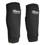 Pair of black Shadow Shinners Shin Pads (Pair) shown from front and side angles on a white background, ideal for riders seeking extra leg protection alongside their usual gear.