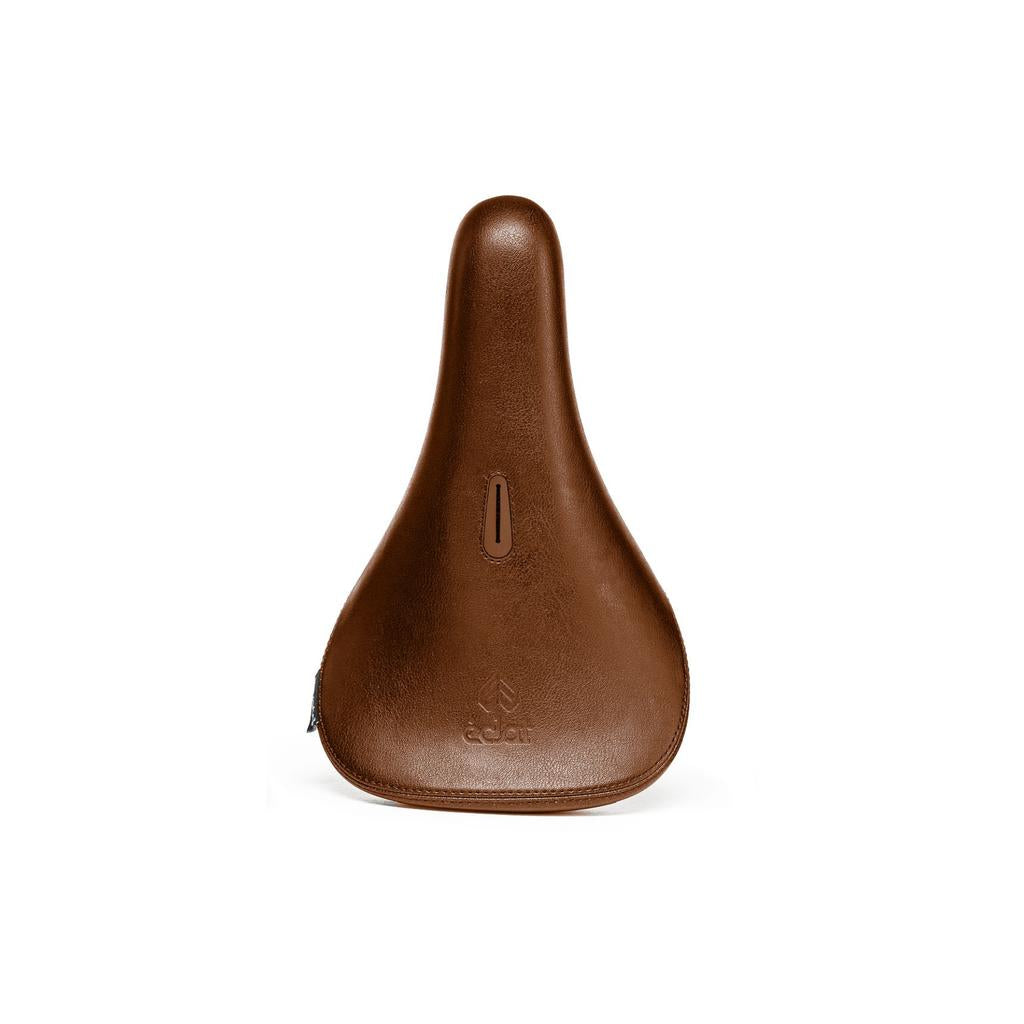 The Eclat Exile Pivotal Seat is a brown leather BMX seat with a smooth surface, a small vertical slot near the center, and an embossed brand logo near the bottom.