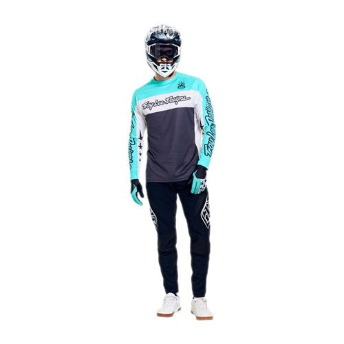 Person wearing a full motocross outfit with helmet, gloves, long-sleeve jersey, and TLD 26.1 Sprint Pro Pants / Mono Black made from durable 4-way stretch fabric, standing against a white background.