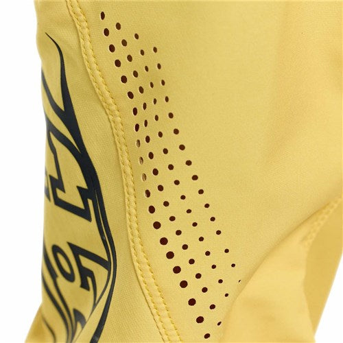 Close-up of yellow 4-way stretch fabric with brown dotted ventilation and a black graphic on the left, featured on TLD 26.1 Sprint Pro Pants (Youth) / Mono Butter riding pants.