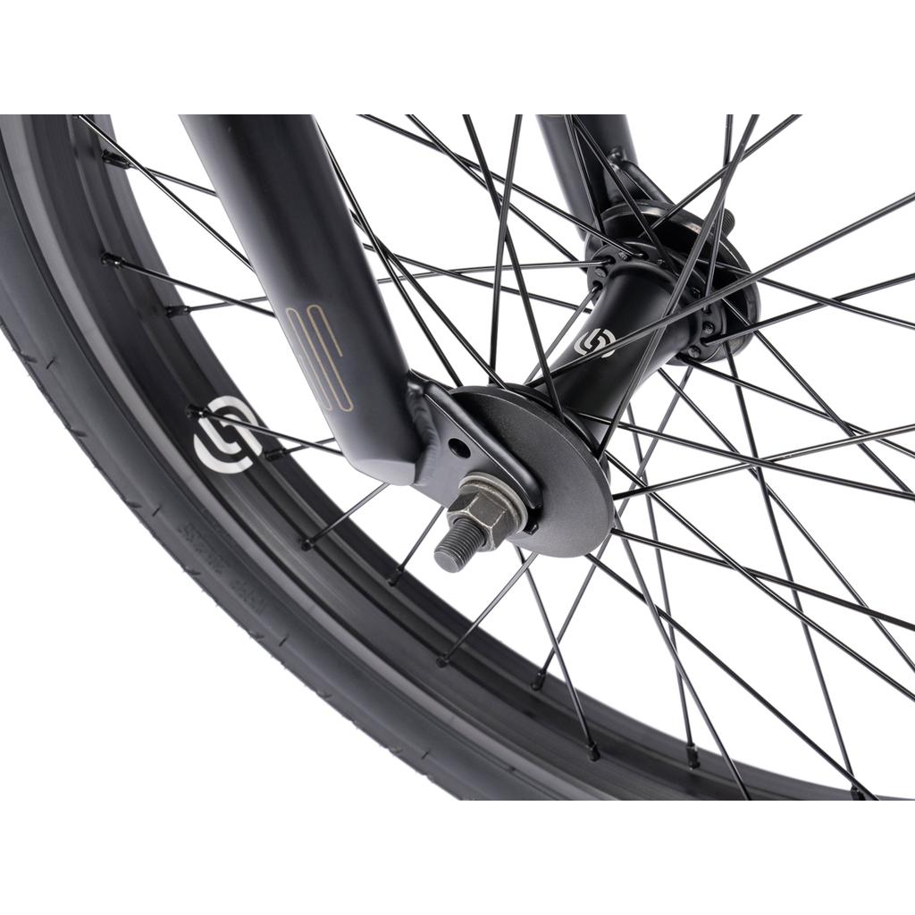 Close-up of a black Wethepeople Arcade 20 Inch Bike wheel with Salt Valon rims, showcasing spokes, tire, axle, and mounting hardware against a white background.