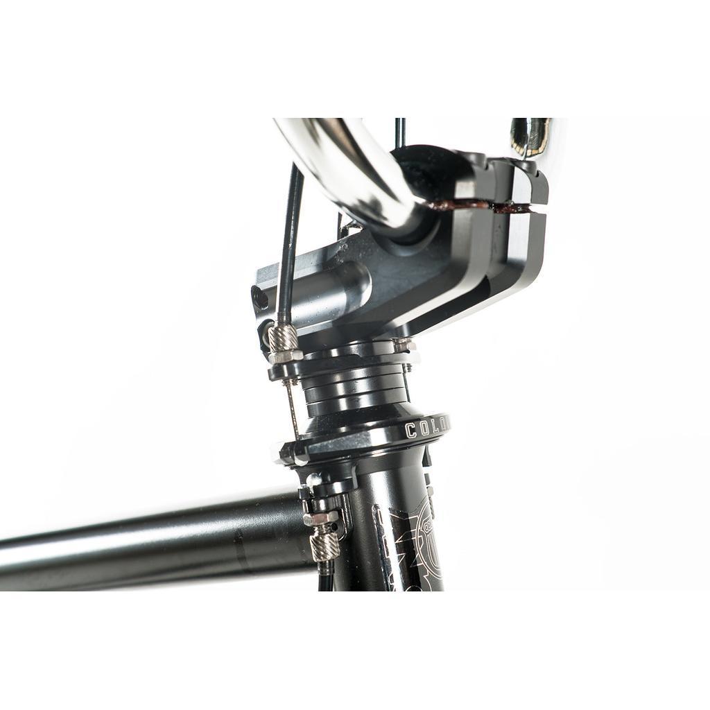 Close-up view of the Colony Prody Pro 20 Inch Bike's mid school BMX headset and stem assembly, displaying the handlebars, bolts, spacers, and part of the frame against a white background.