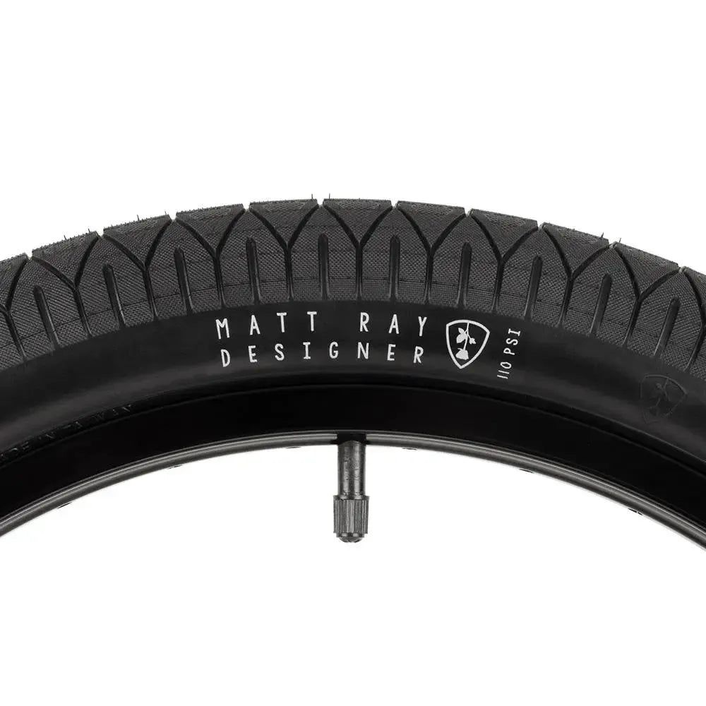 A close-up of the Subrosa Designer Tyre, a Matt Ray signature BMX street tyre, mounted on a rim with a 110 PSI recommended pressure and visible valve—ideal for riders seeking top performance.